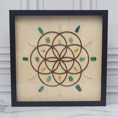 Abundance crystal grid in a black glass-front shadow box, front view