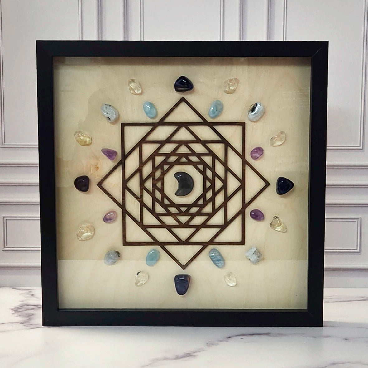 Lunar Energy for Inner Intuition crystal grid in a black glass-front shadow box, front view