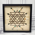 Manifestation crystal grid in a black glass-front shadow box, front view