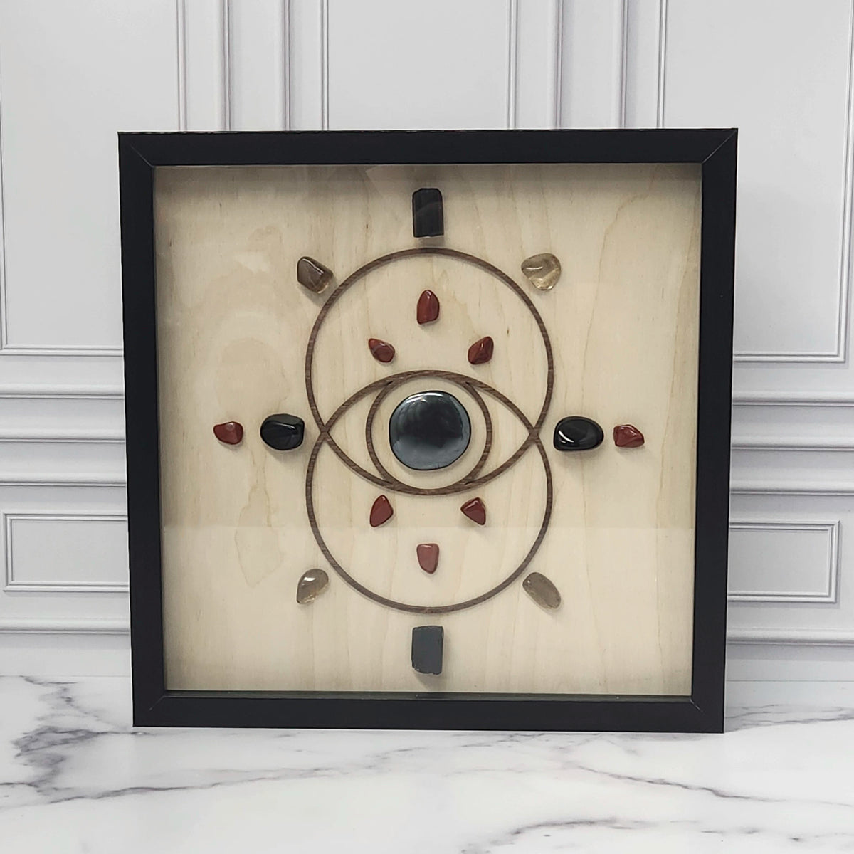 Protection crystal grid in a black glass-front shadow box, front view