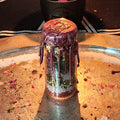 The Self-Love Spell Jar: a small glass jar layered with salt, herbs and stones, sealed with dark pink wax and a gold stamp, on a tray scattered with rose petals